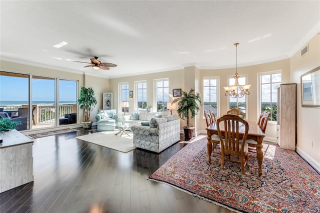 living room with dark wood-type flooring, a wealth of natural light, a water view, and ornamental molding