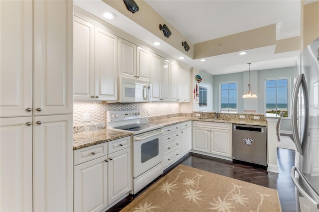 kitchen featuring white cabinets, kitchen peninsula, sink, appliances with stainless steel finishes, and decorative light fixtures