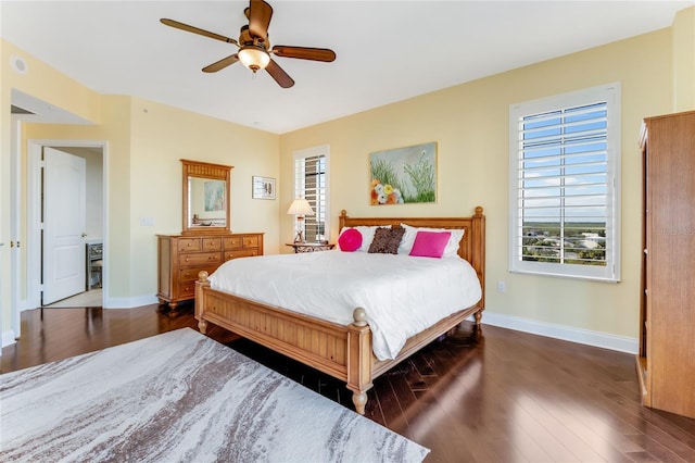 bedroom featuring ceiling fan, multiple windows, and dark hardwood / wood-style floors