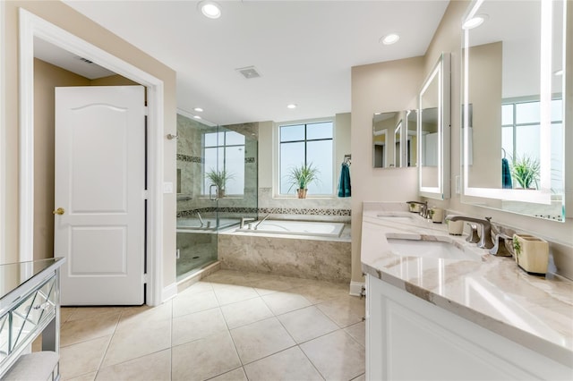 bathroom featuring plus walk in shower, vanity, and tile patterned floors