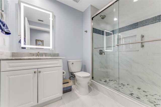 bathroom featuring toilet, an enclosed shower, and vanity