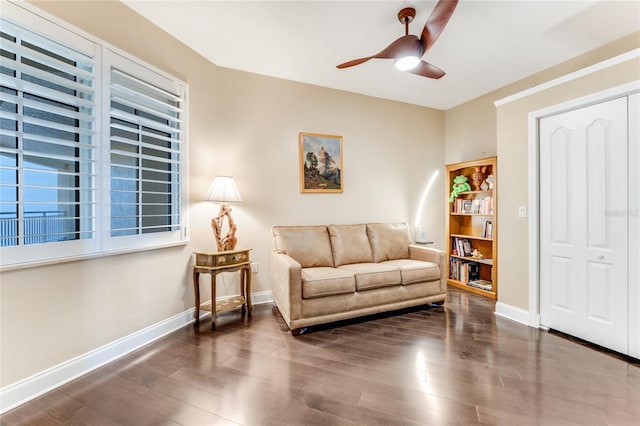 living area featuring dark hardwood / wood-style flooring and ceiling fan