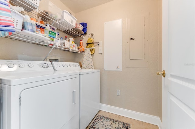 laundry area featuring washing machine and clothes dryer, tile patterned flooring, and electric panel