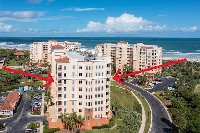 birds eye view of property with a water view and a beach view