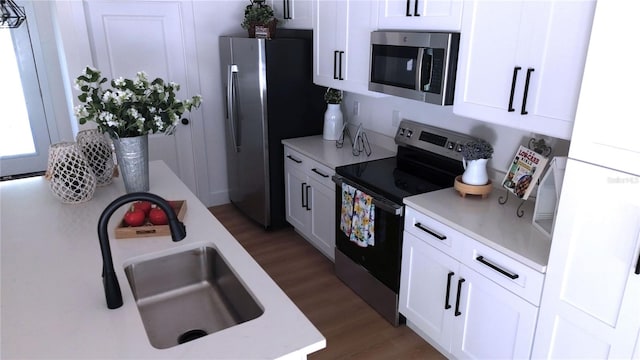 kitchen with white cabinets, sink, dark hardwood / wood-style flooring, and stainless steel appliances