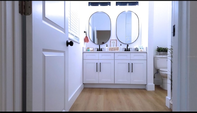 bathroom with hardwood / wood-style floors, vanity, and toilet