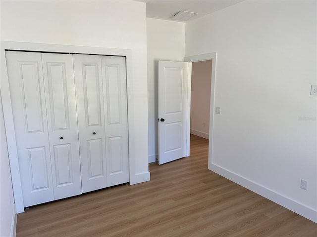 unfurnished bedroom with a closet and hardwood / wood-style floors