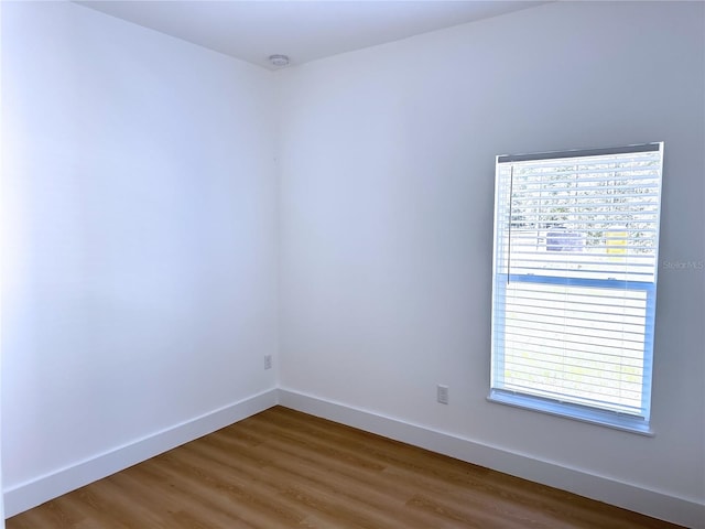 empty room with plenty of natural light and hardwood / wood-style floors