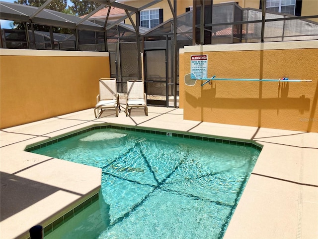 view of pool featuring a patio area and glass enclosure