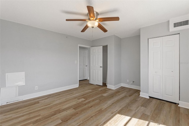 unfurnished bedroom featuring light wood finished floors, visible vents, ceiling fan, and baseboards
