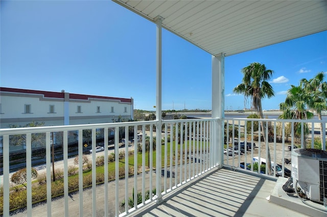 balcony featuring cooling unit and a water view