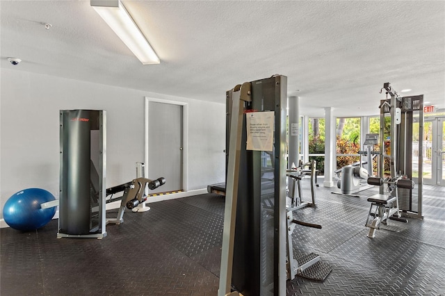 exercise room with expansive windows and a textured ceiling