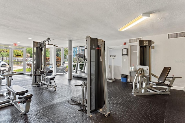 gym featuring a textured ceiling, visible vents, and floor to ceiling windows