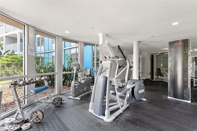gym with a textured ceiling, expansive windows, and recessed lighting