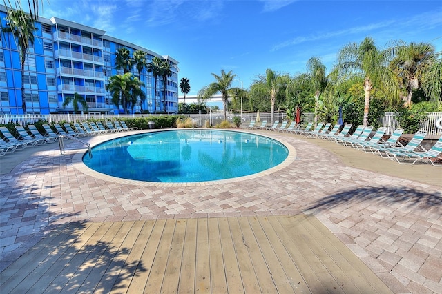 pool featuring fence and a patio area