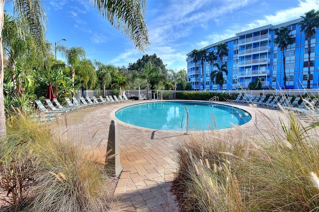 community pool with fence and a patio area