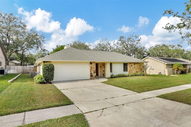 single story home with cooling unit, a front lawn, and a garage