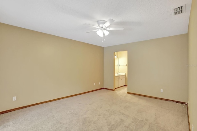 carpeted empty room with ceiling fan and a textured ceiling