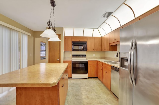 kitchen with sink, a center island, hanging light fixtures, and stainless steel appliances