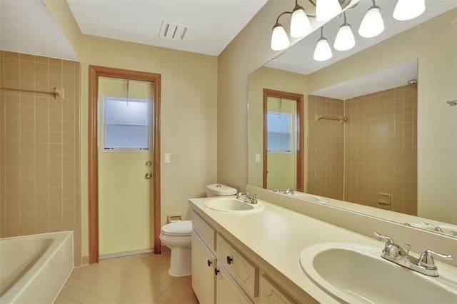 full bathroom with vanity, toilet, tiled shower / bath combo, and tile patterned flooring