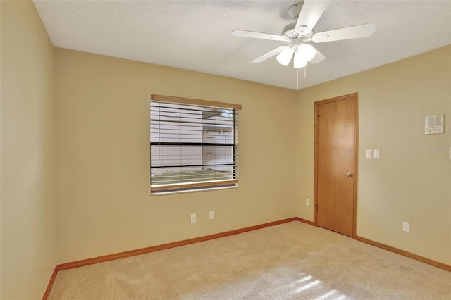 carpeted empty room featuring a textured ceiling and ceiling fan