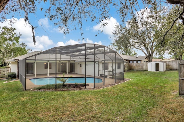 rear view of property featuring glass enclosure, a patio, a fenced in pool, a storage shed, and a lawn