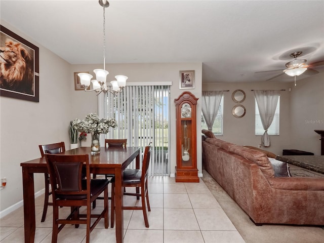 tiled dining area featuring a healthy amount of sunlight and ceiling fan with notable chandelier