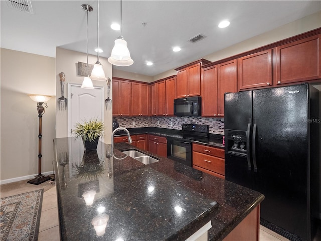 kitchen with a center island with sink, hanging light fixtures, light tile patterned floors, black appliances, and sink