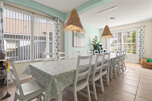 dining area featuring tile patterned floors and a textured ceiling