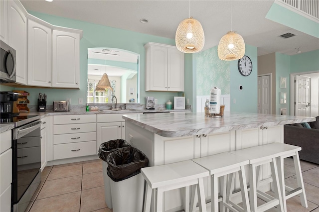 kitchen with white cabinets, a breakfast bar, and appliances with stainless steel finishes