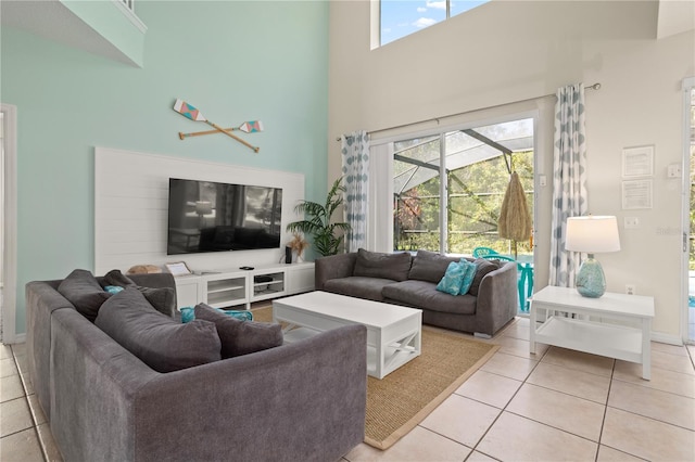 living room with a wealth of natural light, light tile patterned flooring, and a high ceiling