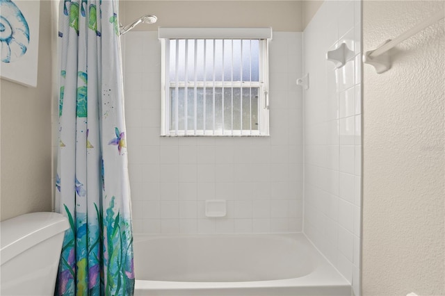 bathroom with shower / bath combo and toilet