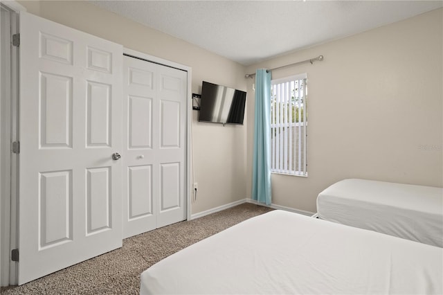 carpeted bedroom featuring a closet and a textured ceiling