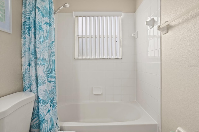 bathroom featuring shower / tub combo and toilet