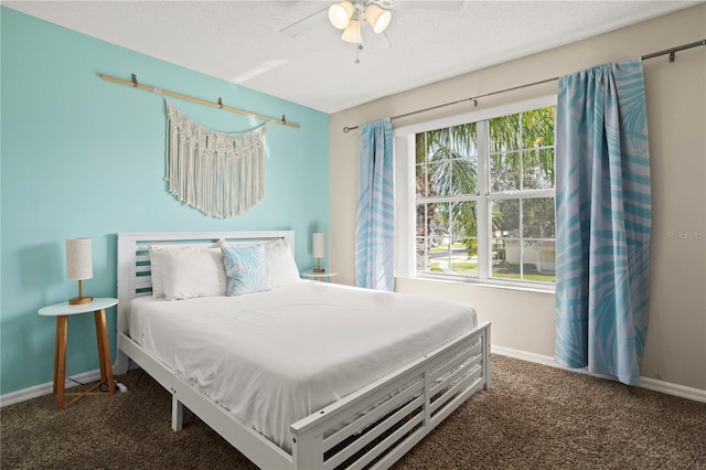 carpeted bedroom featuring ceiling fan and a textured ceiling