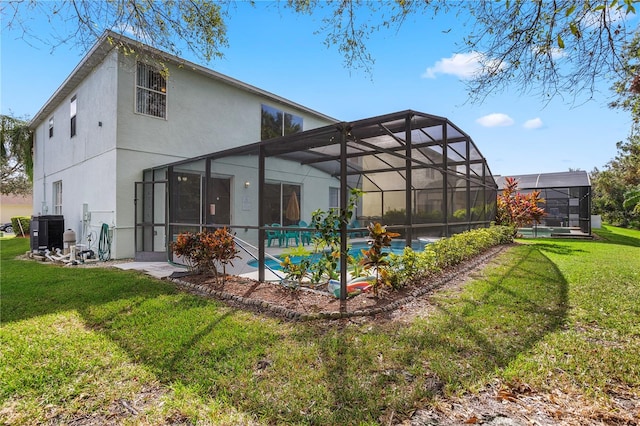 back of house featuring central AC unit, a lanai, and a lawn