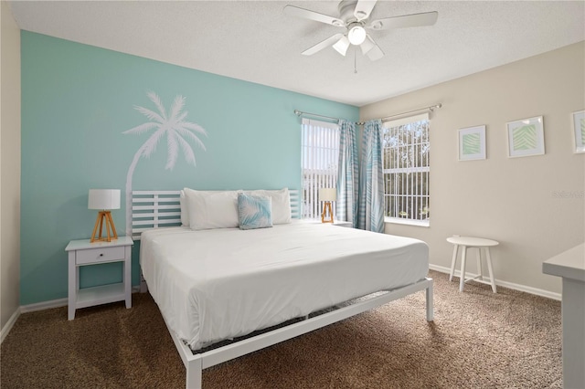 carpeted bedroom with ceiling fan and a textured ceiling