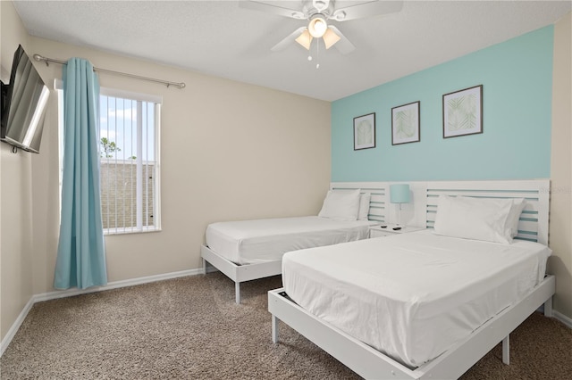 bedroom with ceiling fan, carpet, and a textured ceiling