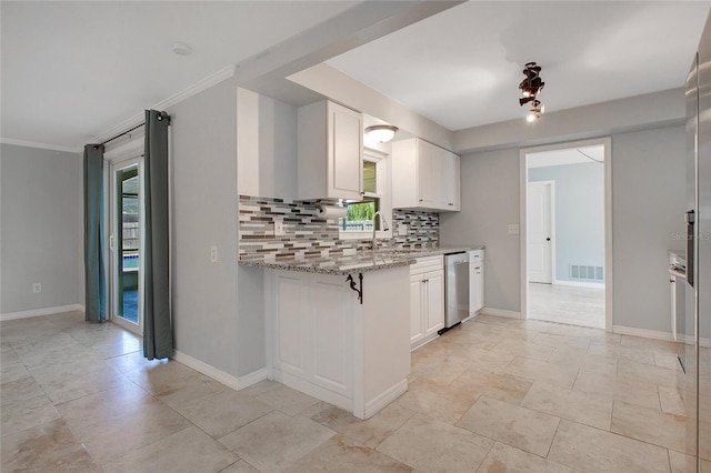 kitchen with tasteful backsplash, light stone countertops, white cabinetry, stainless steel dishwasher, and ornamental molding