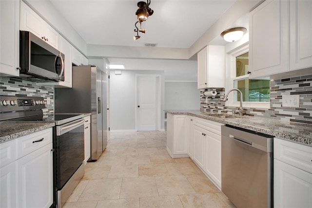 kitchen featuring white cabinetry, light stone counters, stainless steel appliances, and decorative backsplash