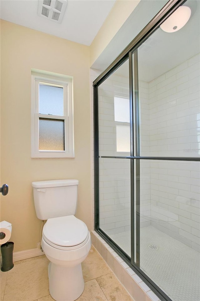 bathroom with toilet, an enclosed shower, and tile patterned floors