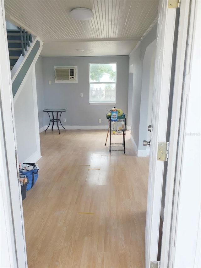 hall with a wall mounted AC and light hardwood / wood-style flooring