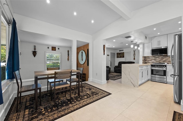 tiled dining space featuring vaulted ceiling with beams