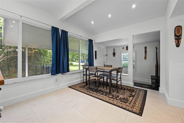 dining area featuring a wealth of natural light, vaulted ceiling with beams, and light tile patterned floors