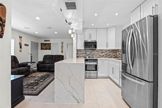 kitchen with tasteful backsplash, light stone counters, light tile patterned floors, white cabinetry, and stainless steel appliances