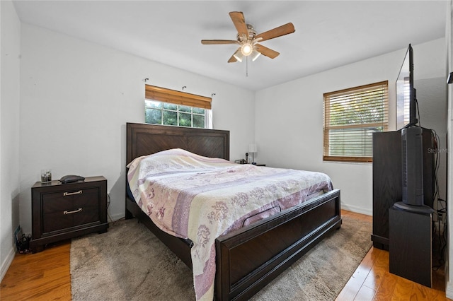 bedroom with light hardwood / wood-style flooring, multiple windows, and ceiling fan