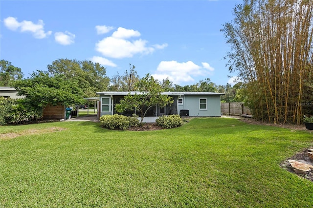 back of house featuring a lawn and a sunroom