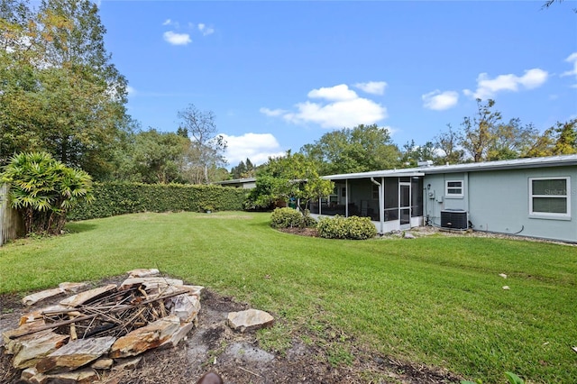 view of yard with central air condition unit and a sunroom