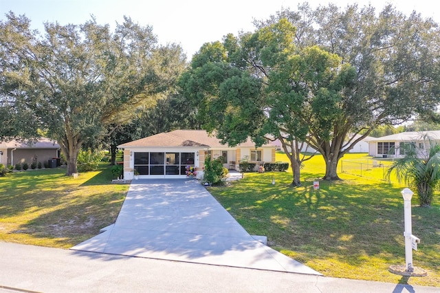 view of front of property featuring a front yard and a sunroom