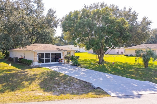 ranch-style house with a front lawn, central AC unit, and a sunroom